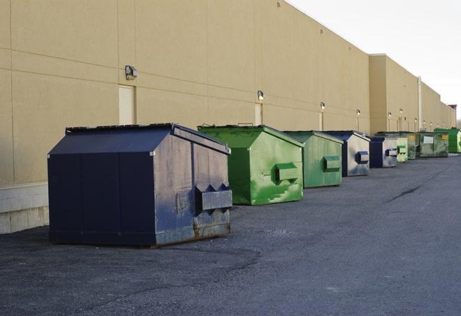 construction workers throw waste into a dumpster behind a building in Bermuda Dunes CA